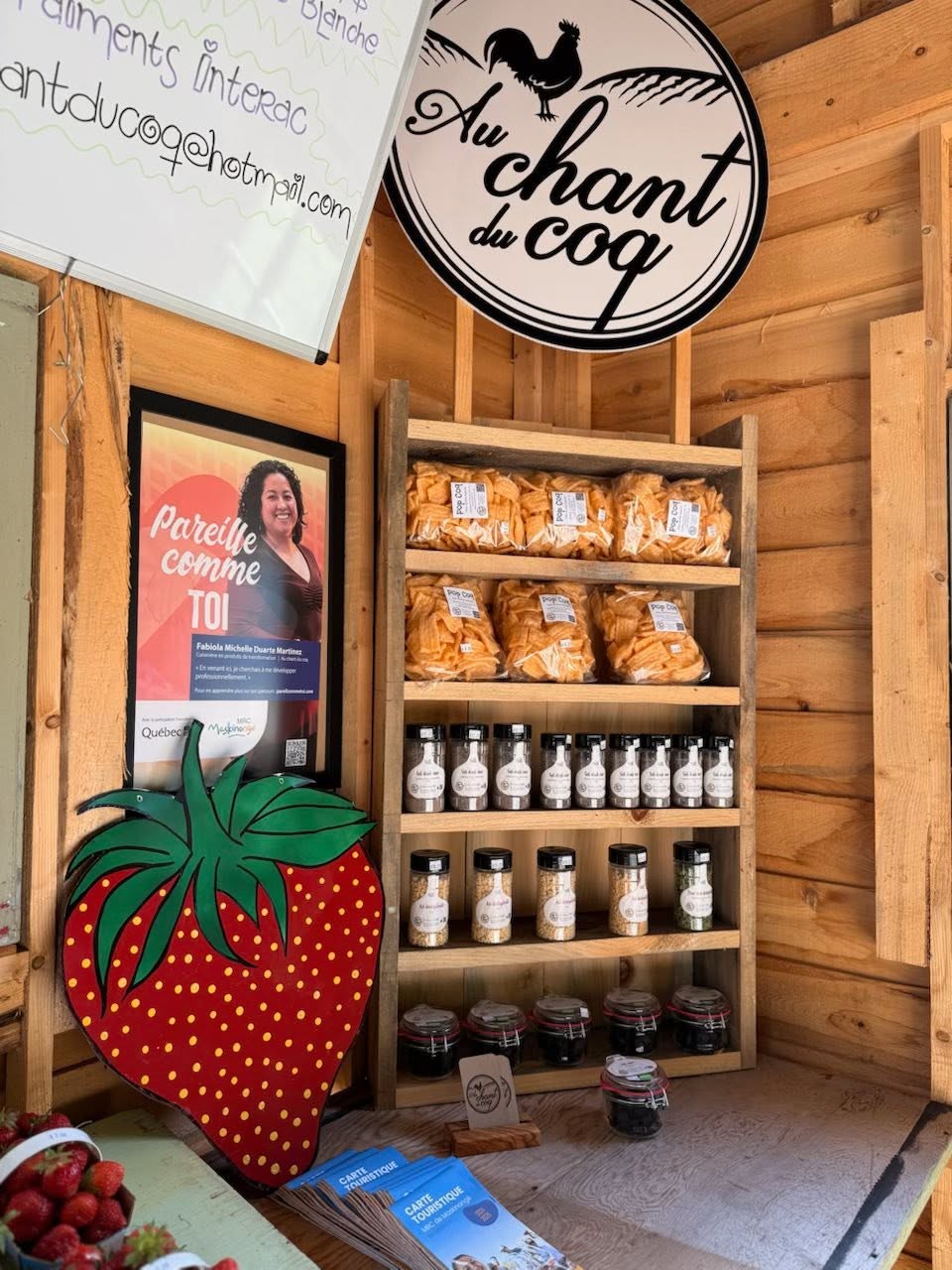 Étagère de produits et enseigne Au Chant du Coq dans la boutique
