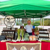 Équipe Au Chant du Coq au marché sous un chapiteau vert