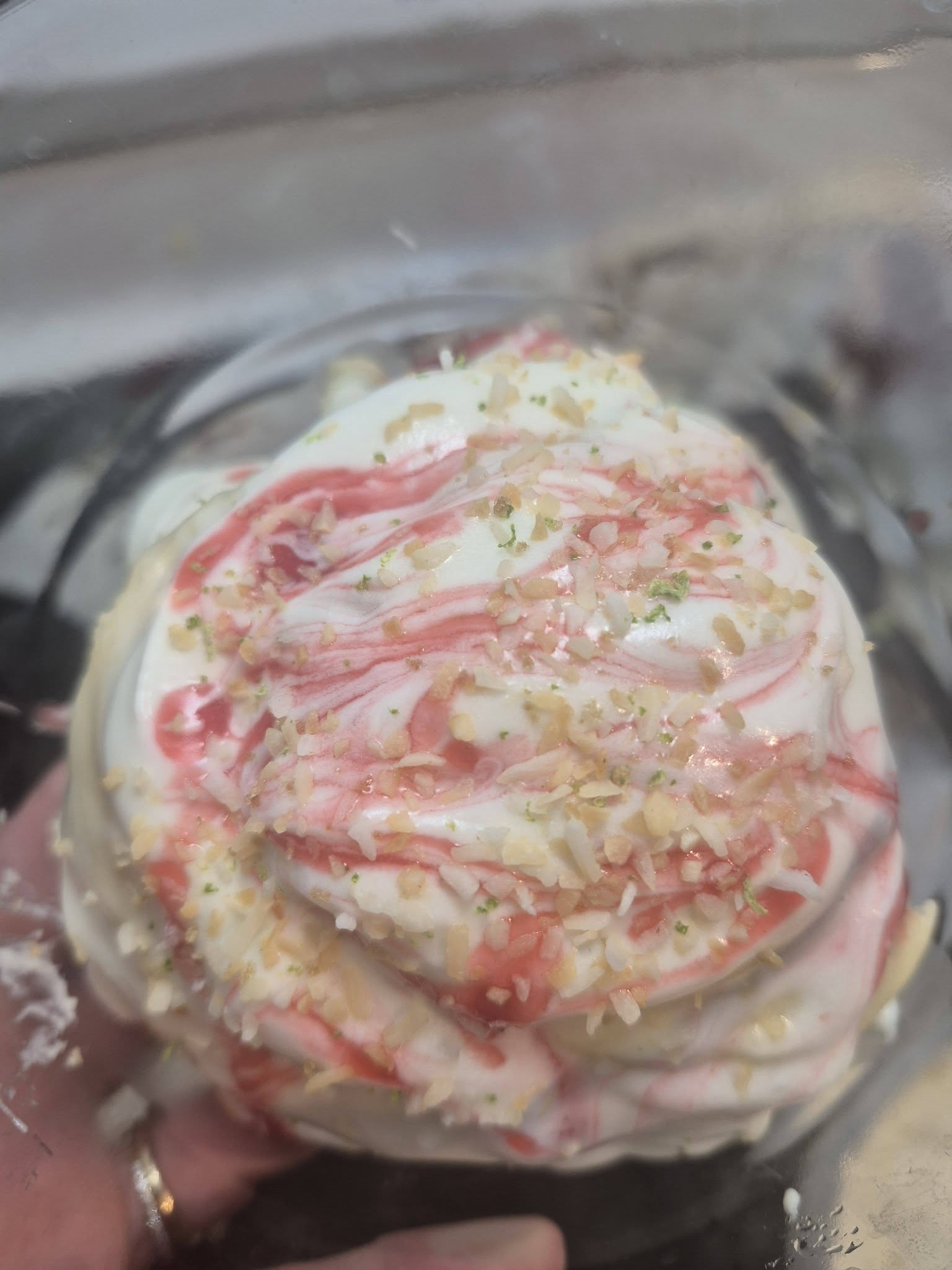 Brioche garnie d’un glaçage rose et blanc et de petits éclats