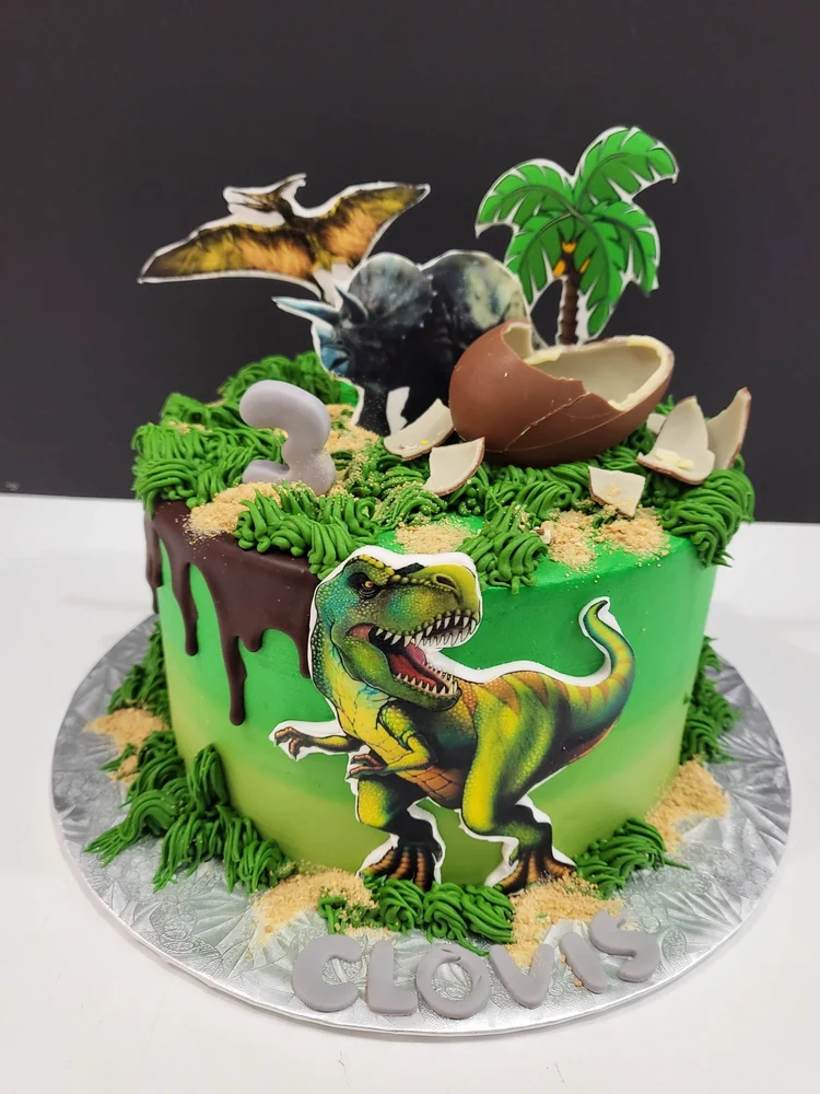 Gâteau vert sur le thème des dinosaures avec un œuf décoratif