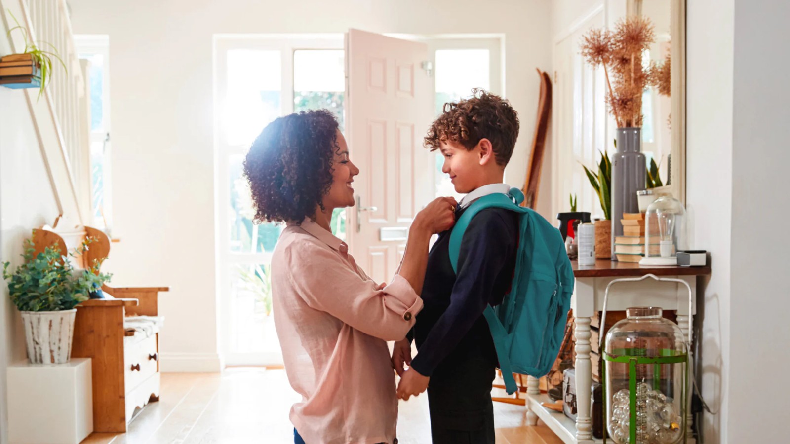 Une mère prépare son enfant avec son sac d’école