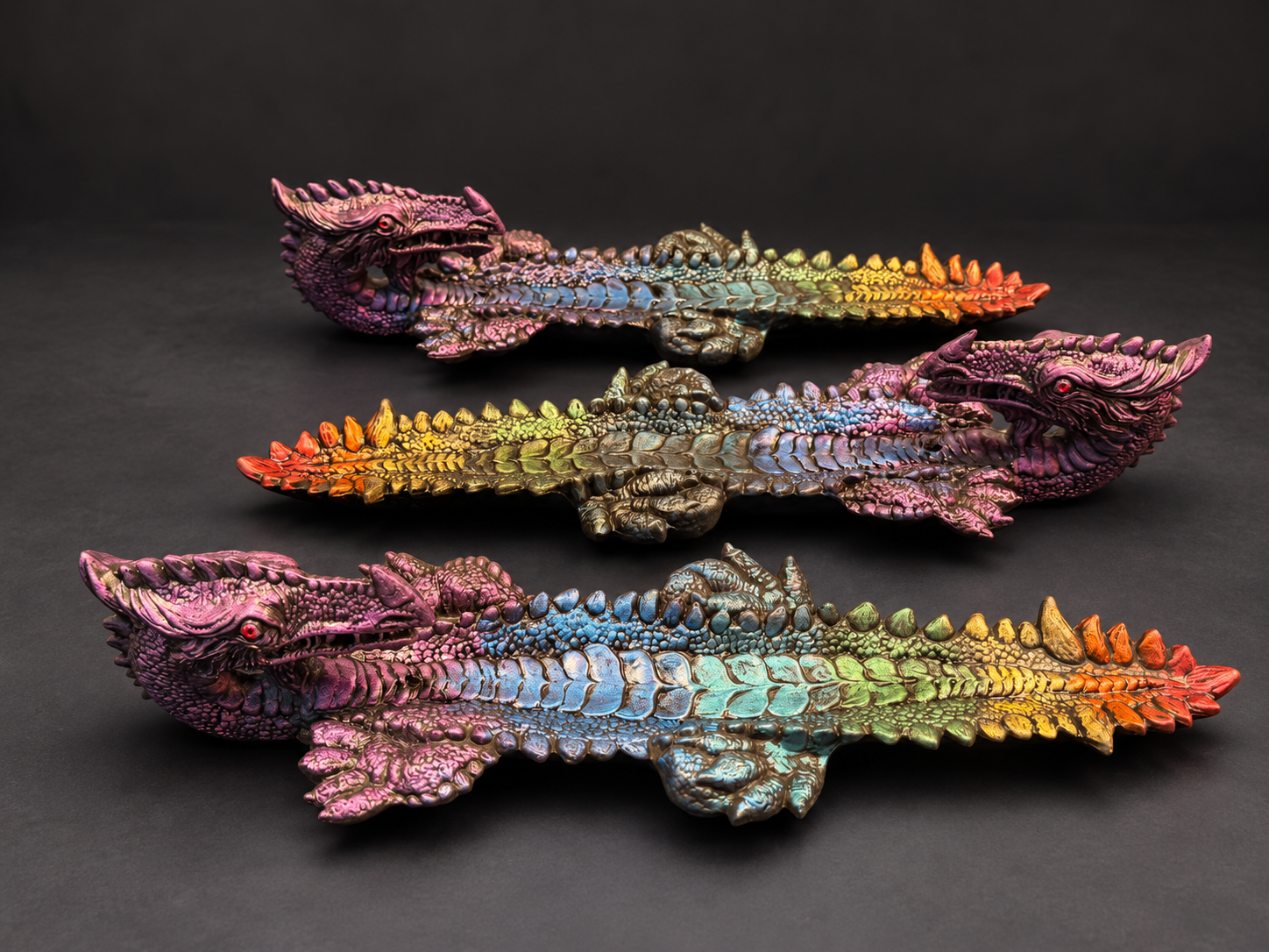 Trois dragons multicolores de C. Dragonia sur fond sombre