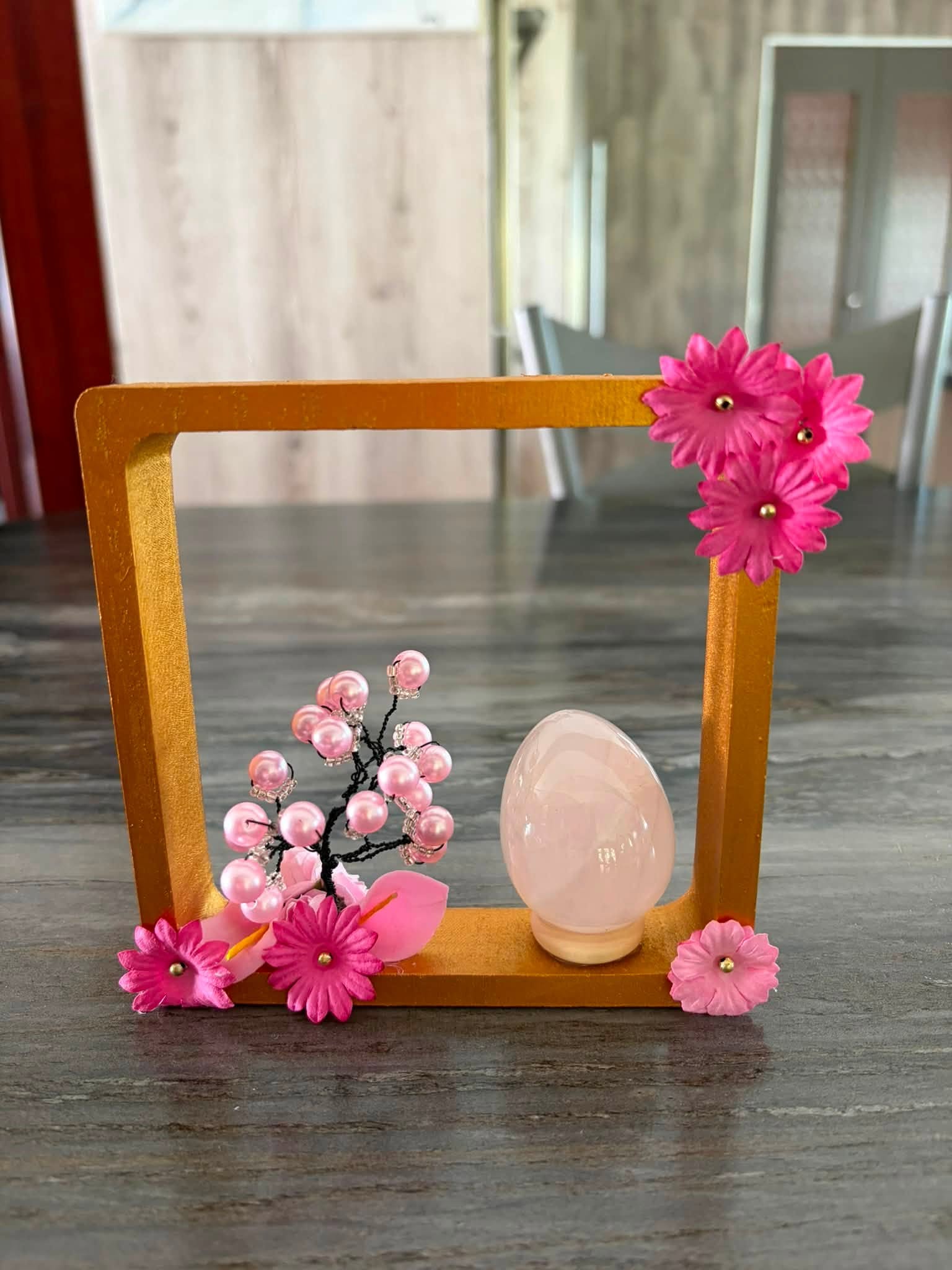 Composition décorative de C. Dragonia dans un cadre doré avec fleurs et arbre roses
