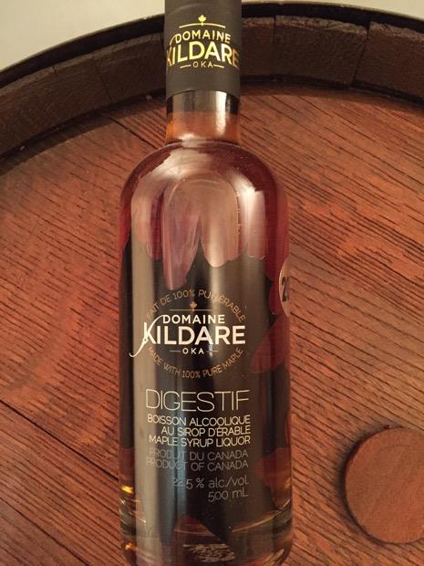 Bouteille de digestif Domaine Kildare présentée sur un tonneau